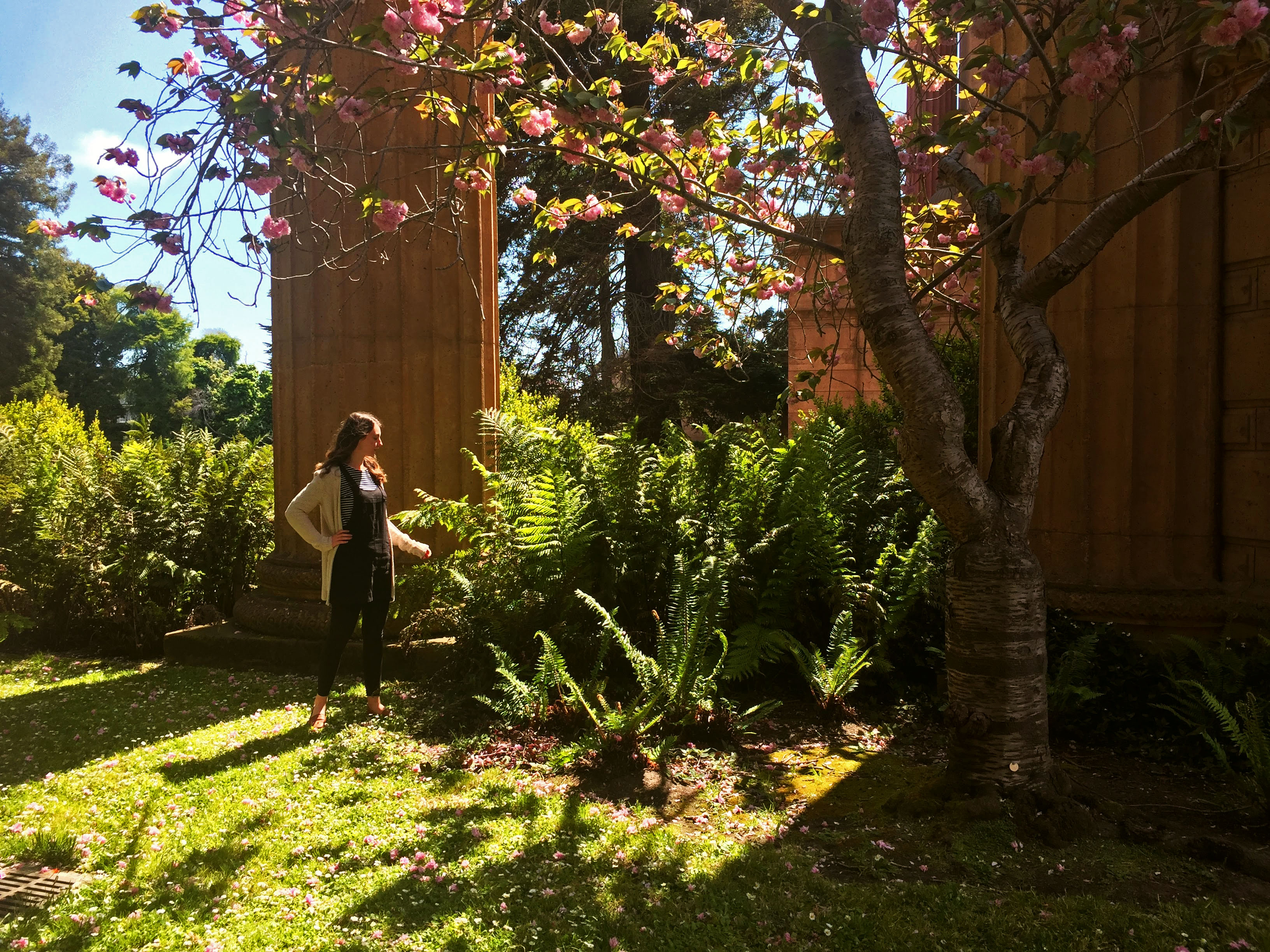 girl standing in garden under tree and pillars